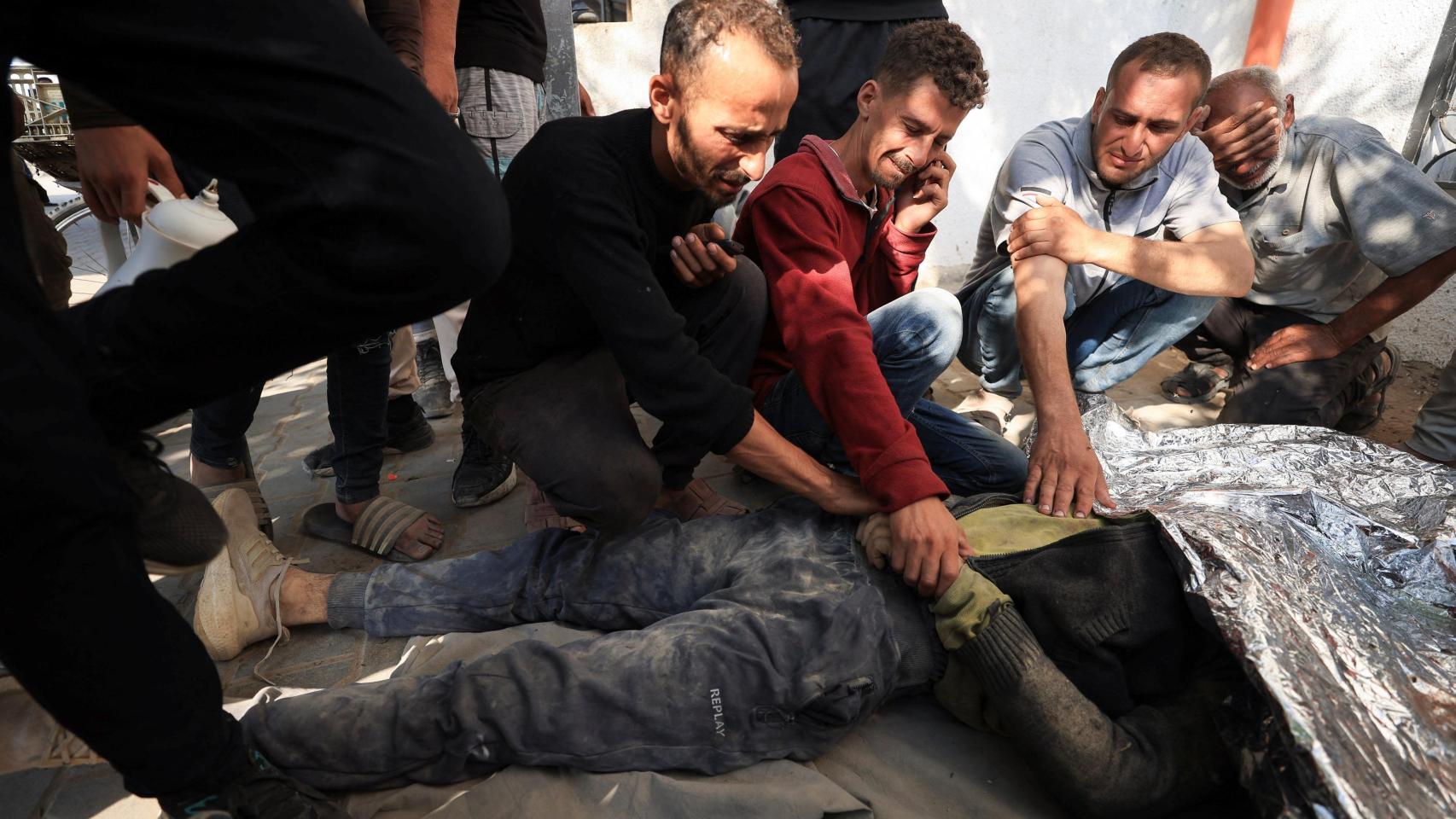 Familiares junto al cadáver de un palestino muerto por un ataque de Israel en Gaza el 11 de junio.